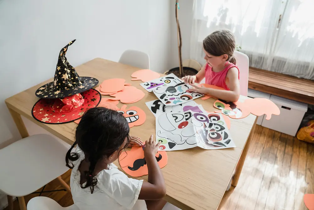 Crianças praticando atividades de colagem para decoração do Halloween